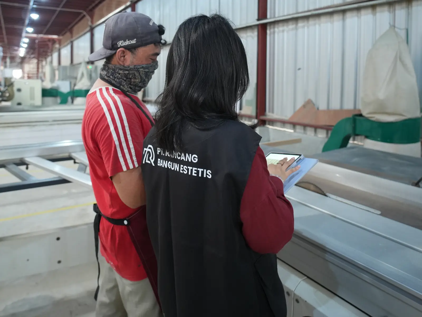 Staf RBE mengecek gambar kerja di tablet bersama operator panel saw
