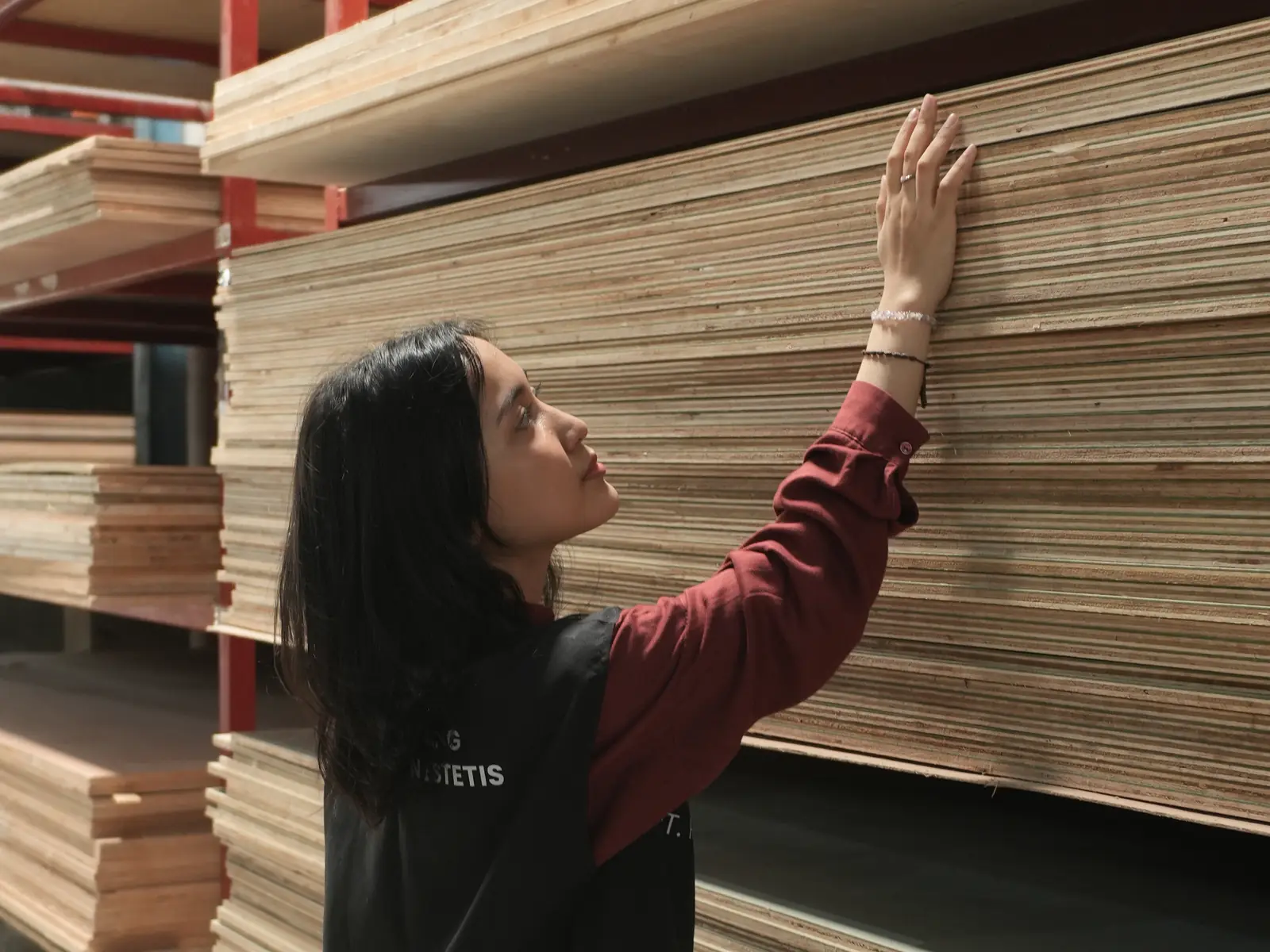 Staf RBE memeriksa tumpukan panel plywood di rak material